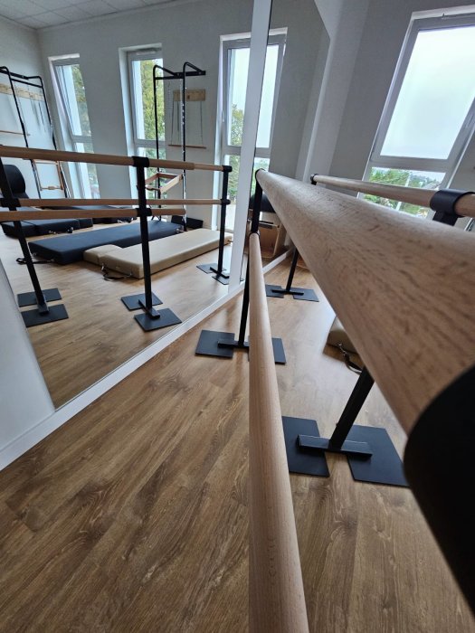 Sala Holica Studio z drążkiem barre, lustrem i oknami